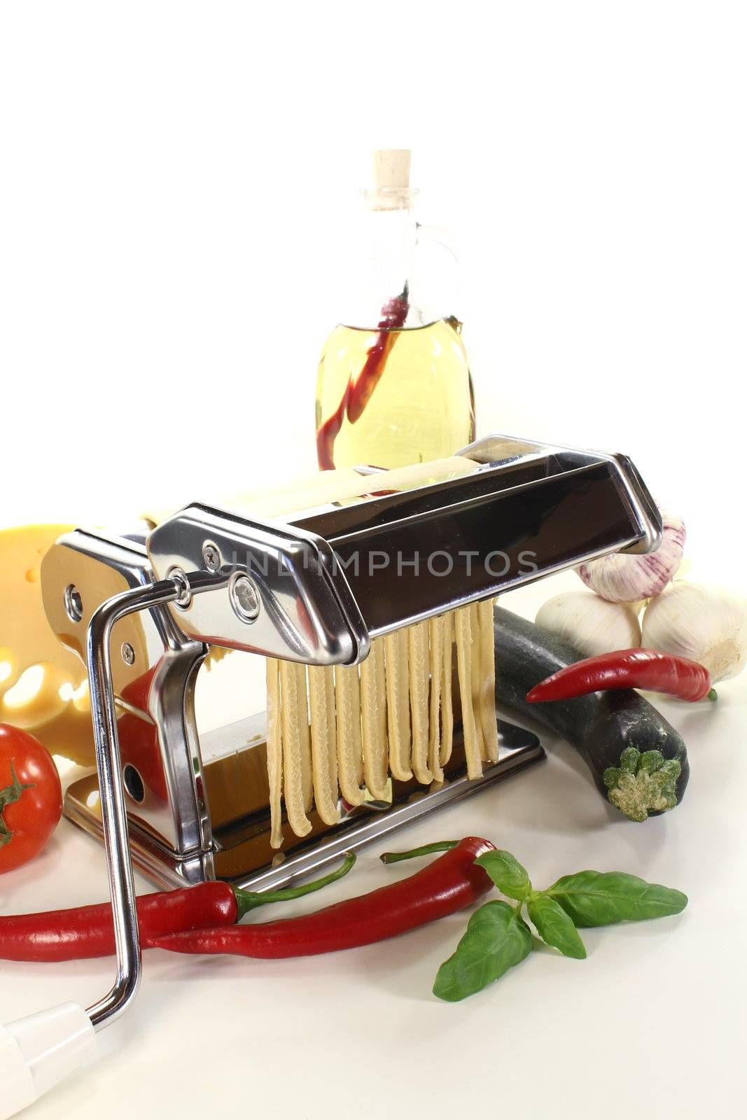 tagliatelle in a pasta machine with tomatoes, garlic and basil