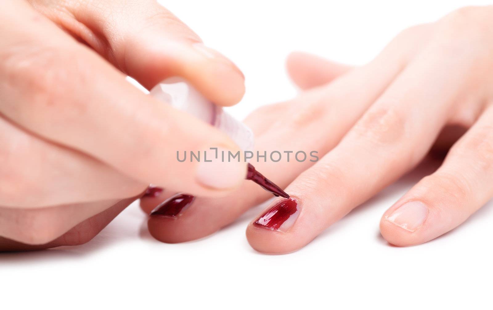 Woman applying nail polish on her fingers by AGorohov