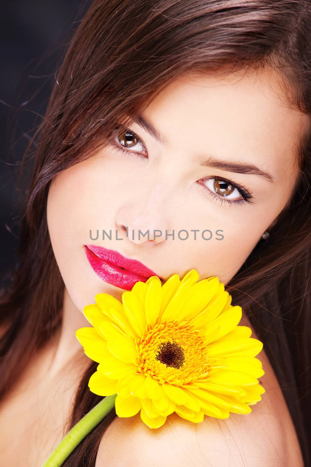 Yellow daisy on pretty woman's shoulder