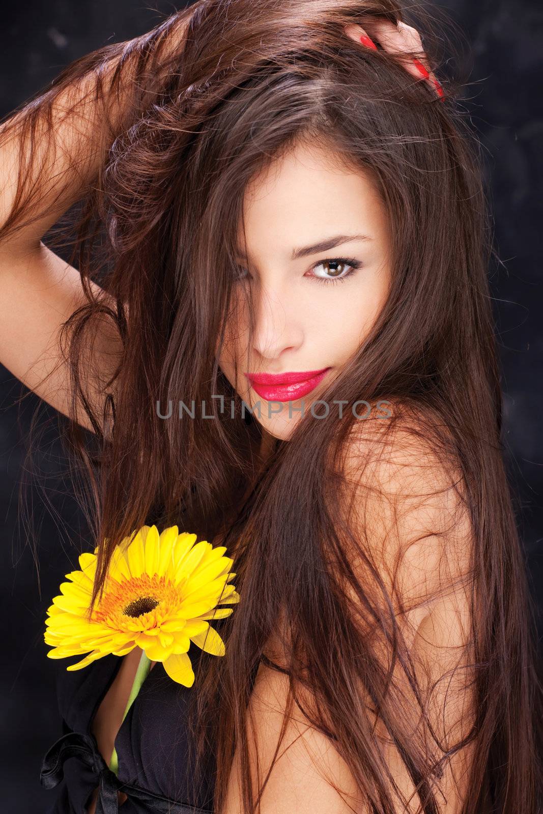 Pretty woman with long hair and yellow daisy