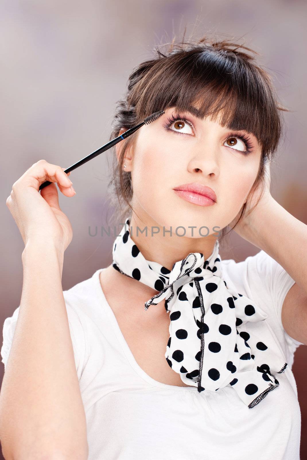 Pretty woman applying makeup on eyelash
