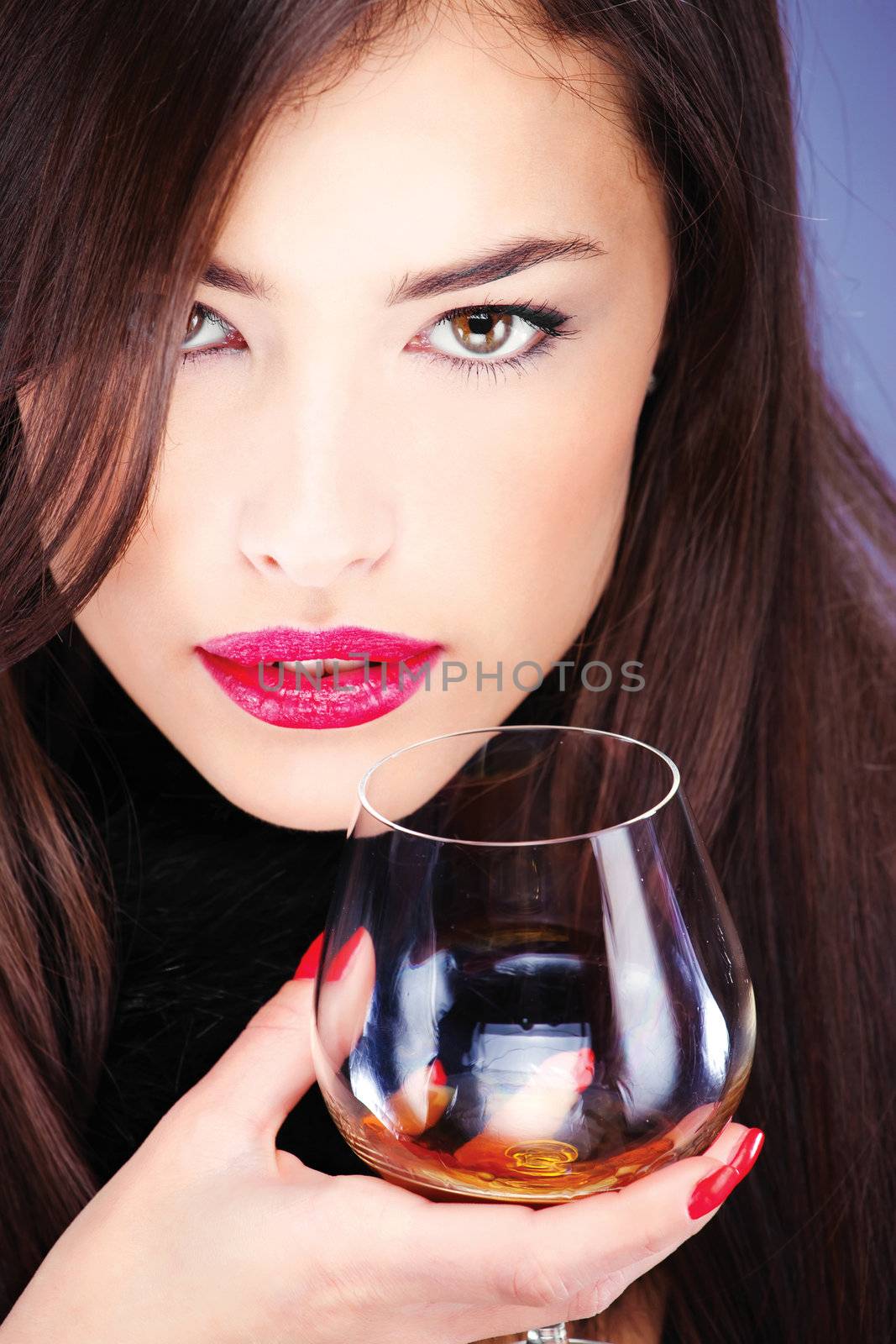 Close up of a woman with pelt, holding glass of brandy