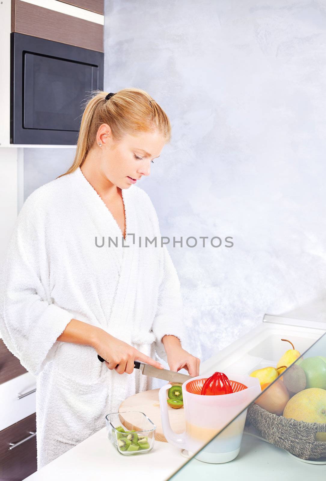 pretty woman making fruit salad in kitchen