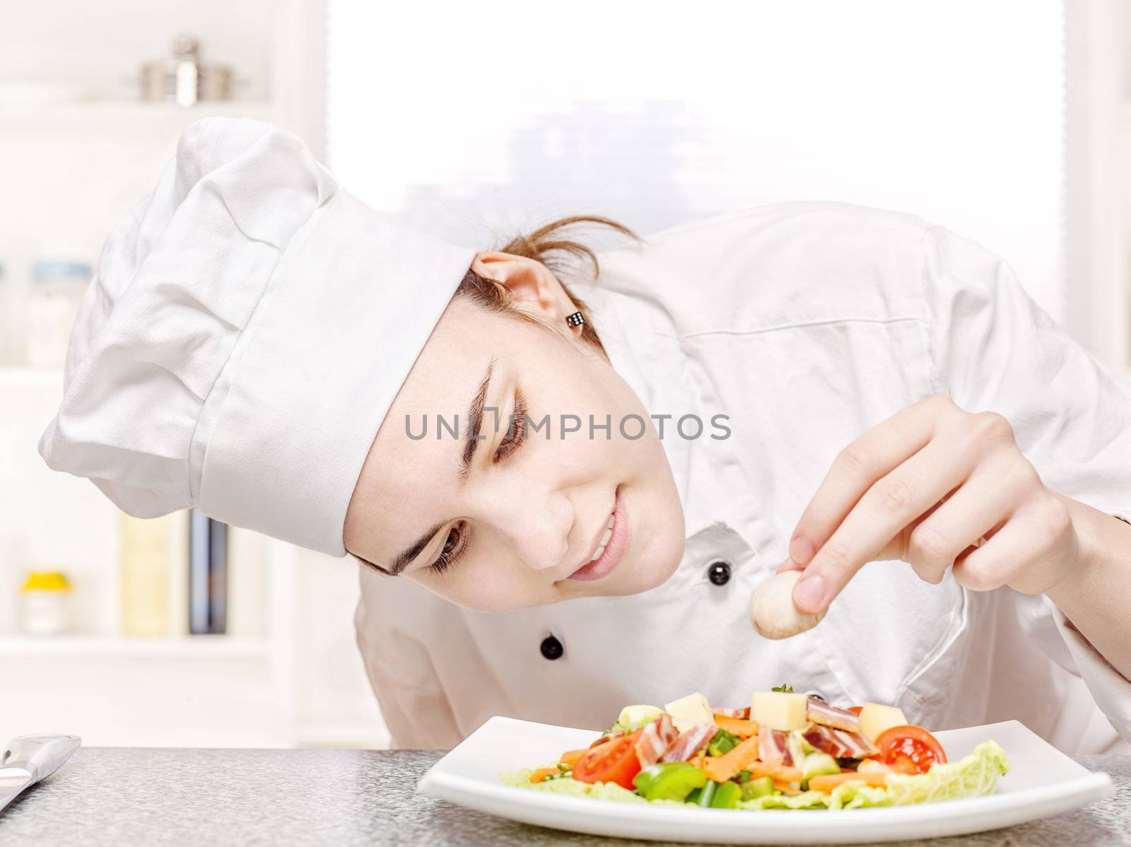 pretty young chef decorating delicious salad