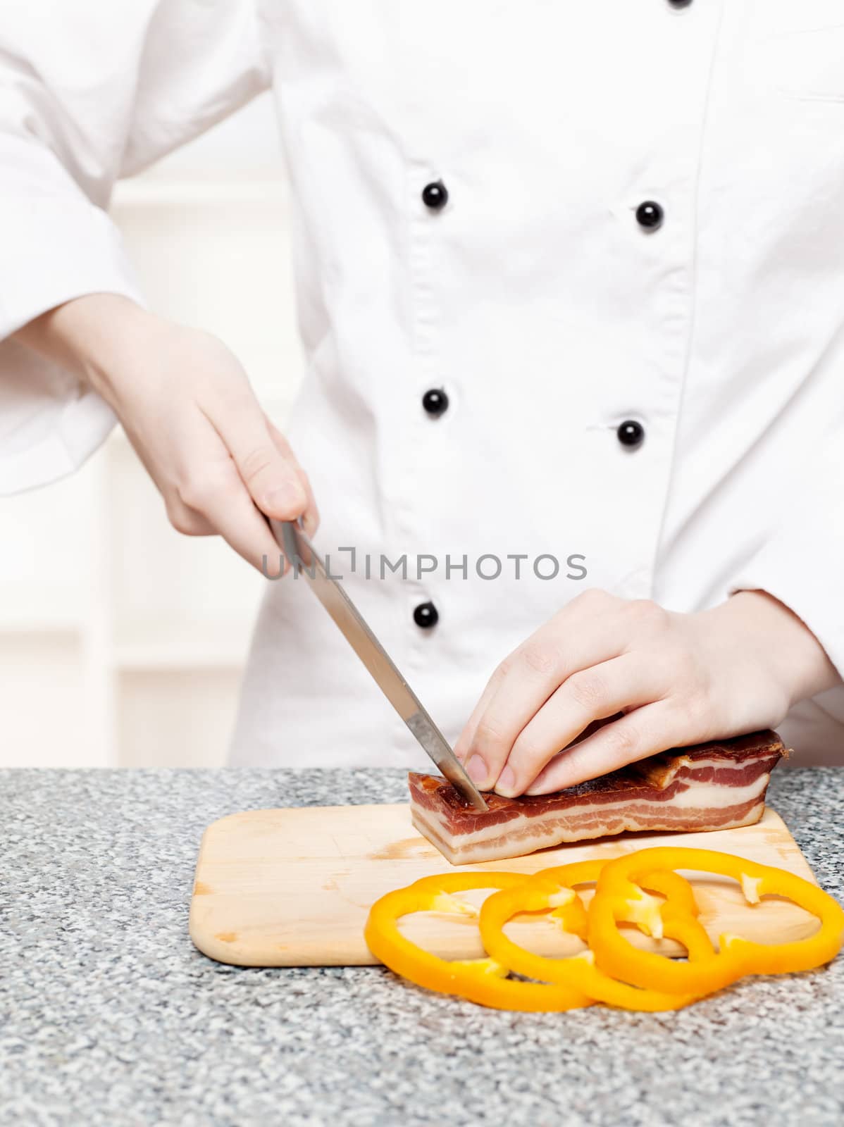 chef cutting bacon on board