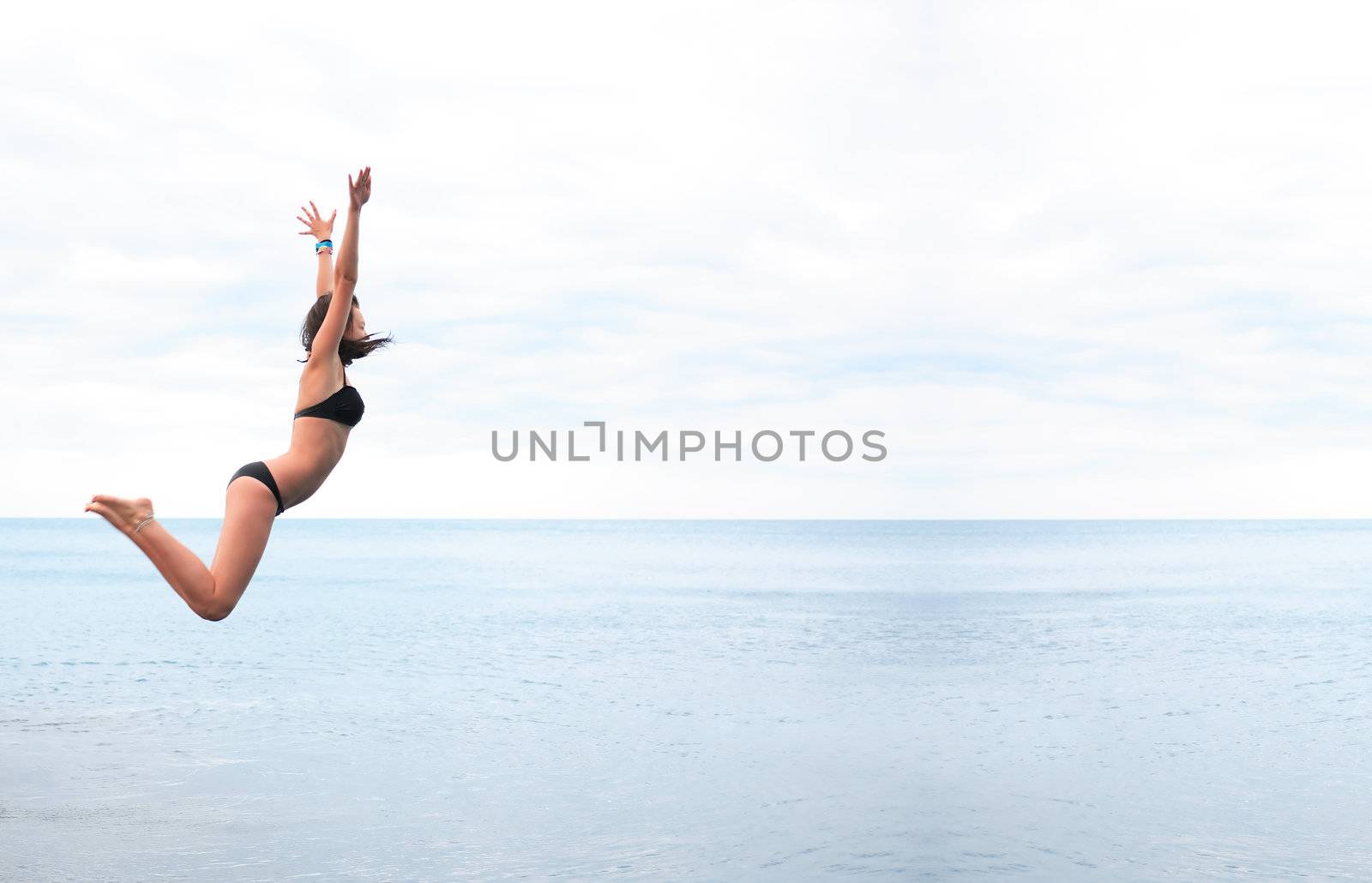 Beauty teenage girl jumping in the sea