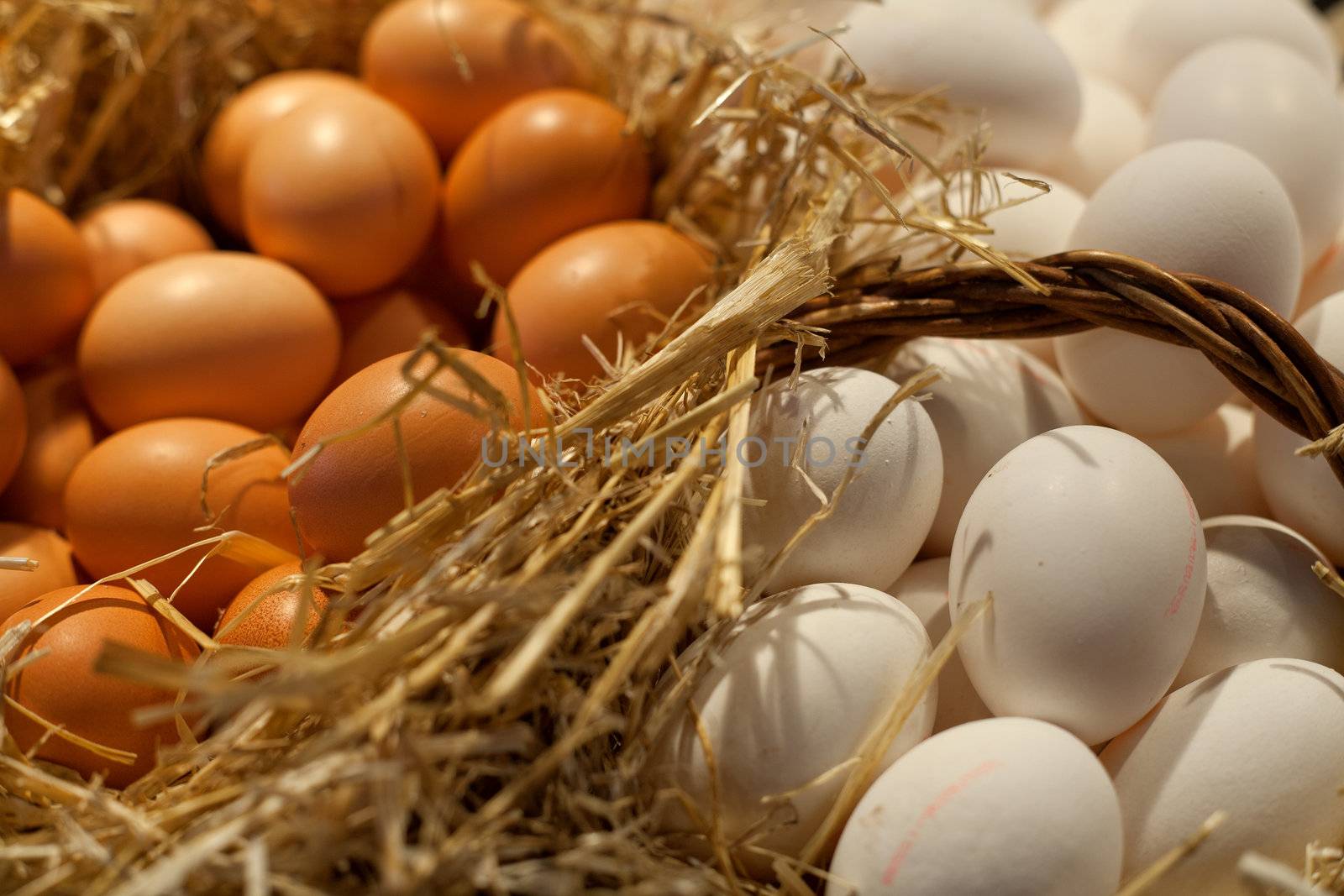 Brown and white eggs on a straw background.