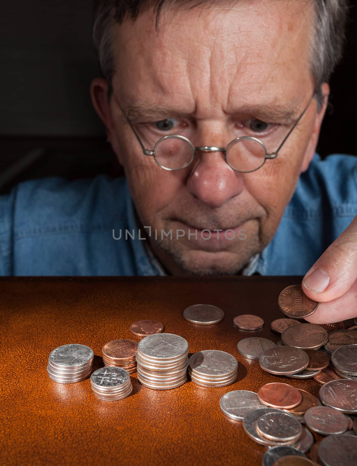 Senior man counting cash into piles by steheap