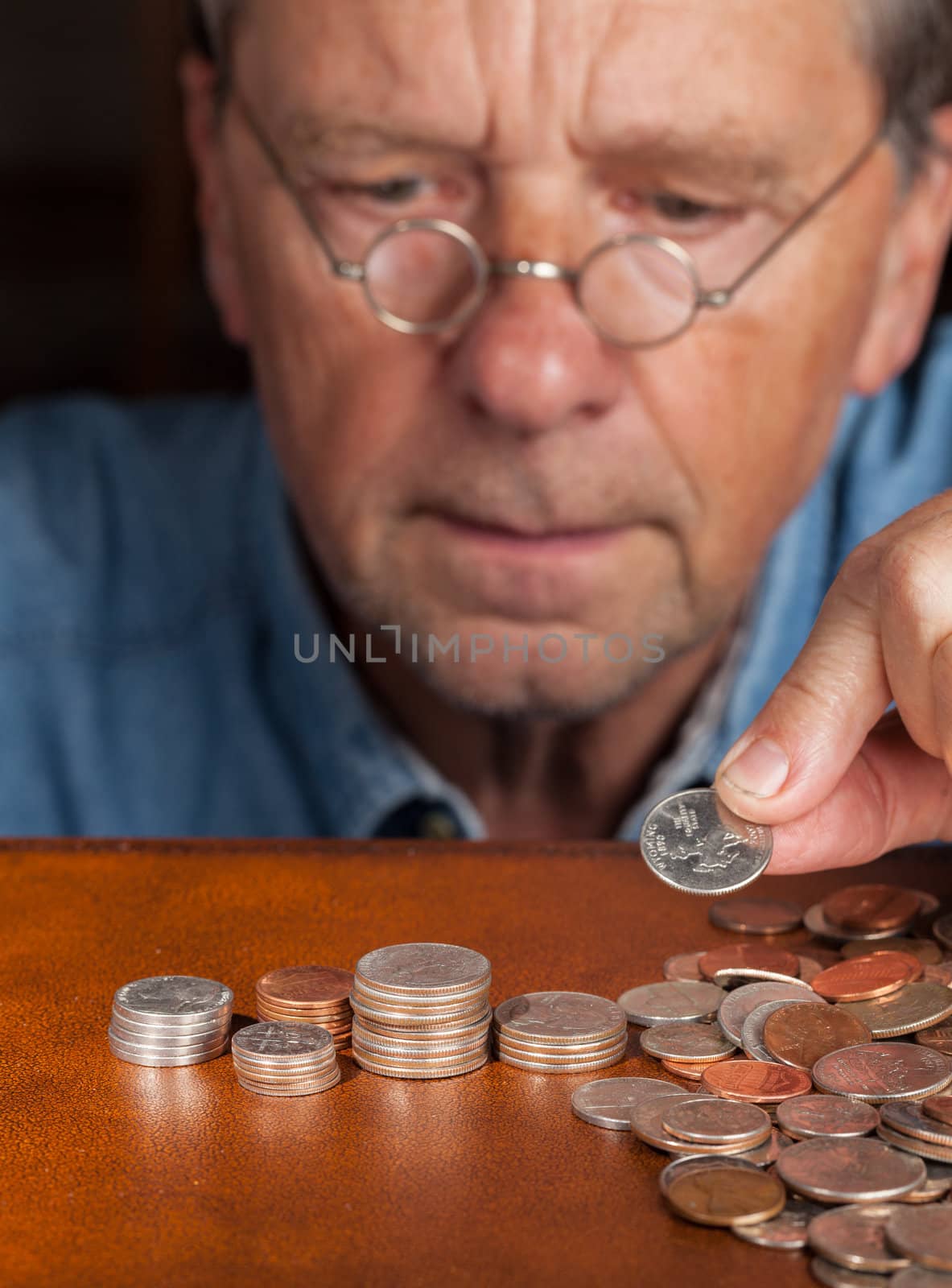 Senior retired caucasian man counting out cash into piles