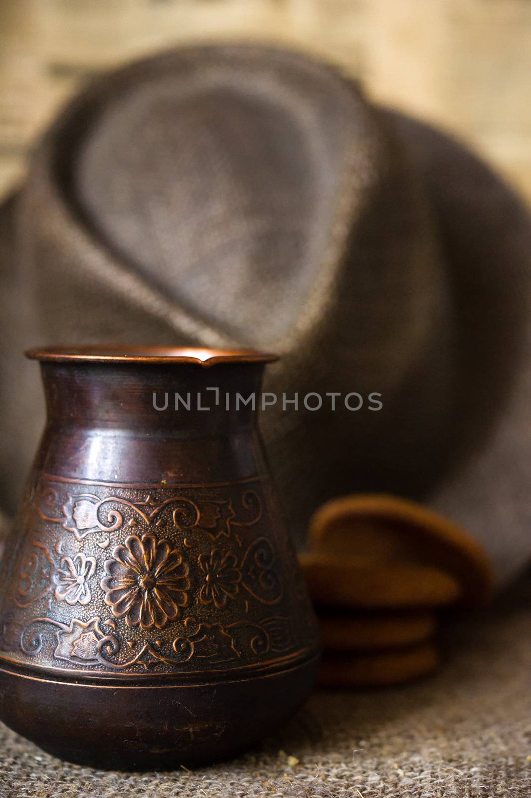 Still life with turkish cezve, men's hat and oatmeal cookies on background. Shallow DOF 
