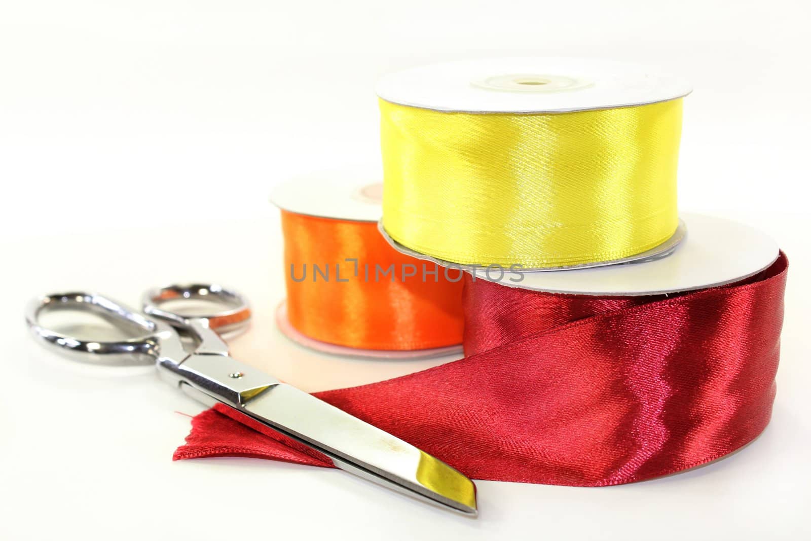 three rolls of ribbon in front of white background