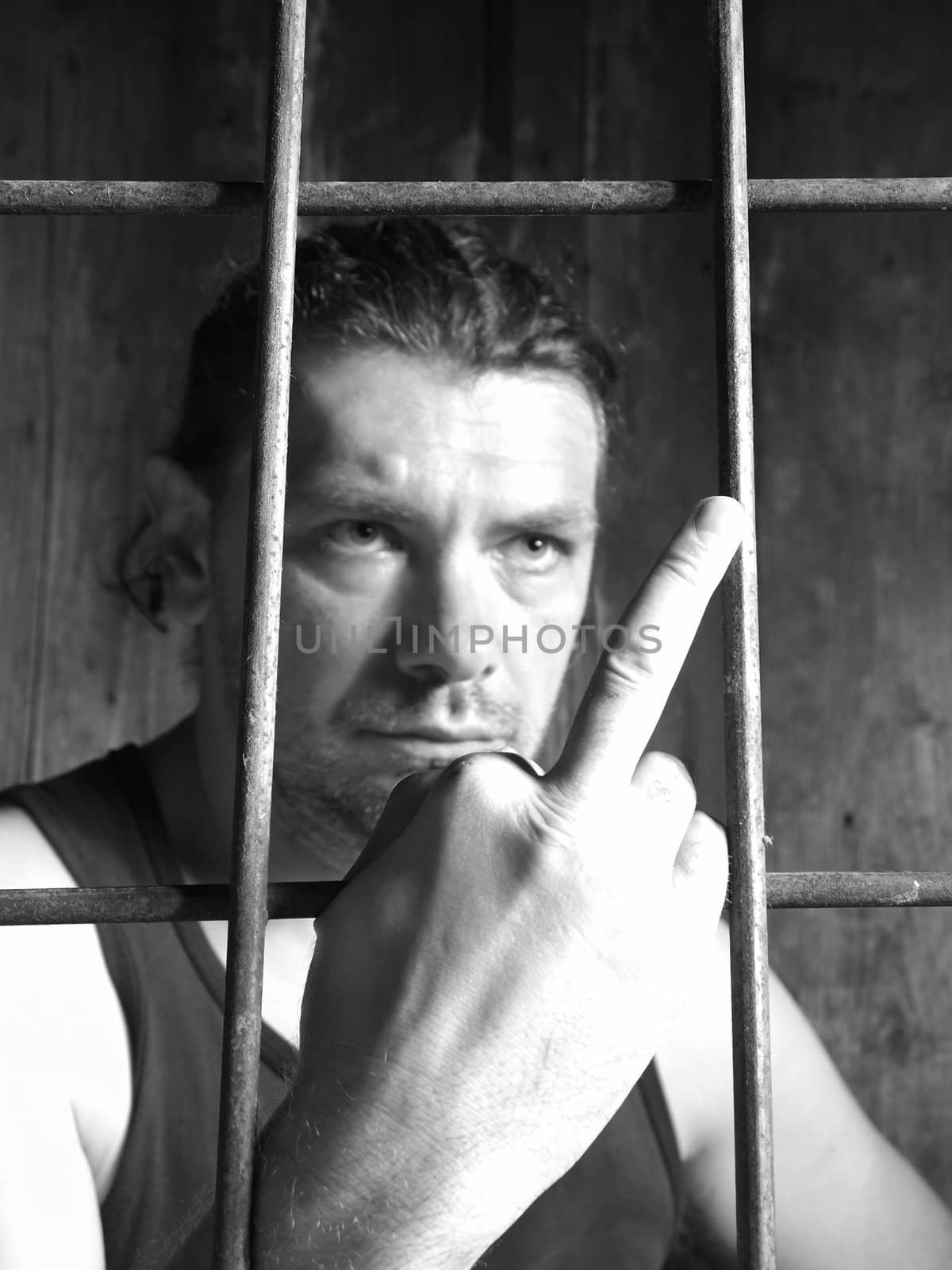 male behind bars, obscene gesture