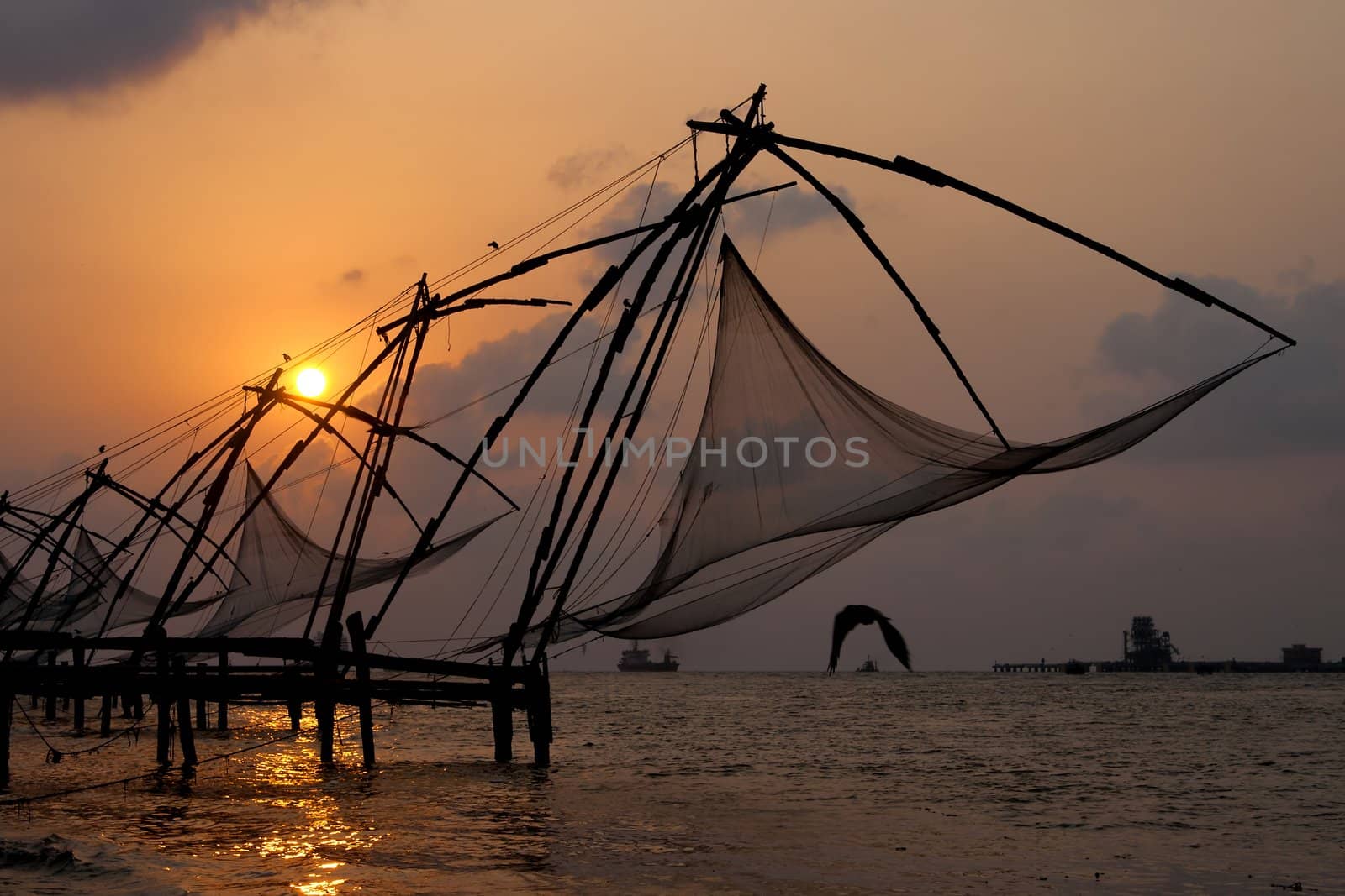 Sunset over Chinese Fishing nets and boat in Cochin (Kochi), Kerala, India.