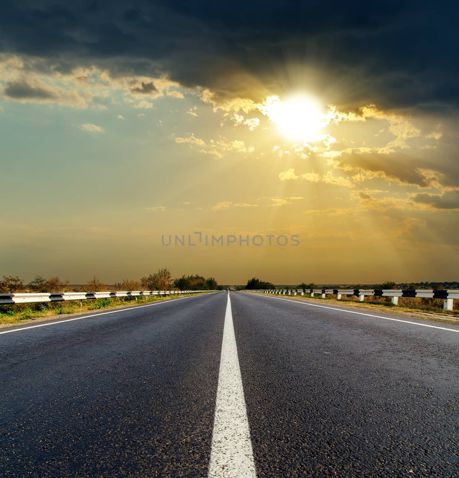 dramatic sunset over asphalt road