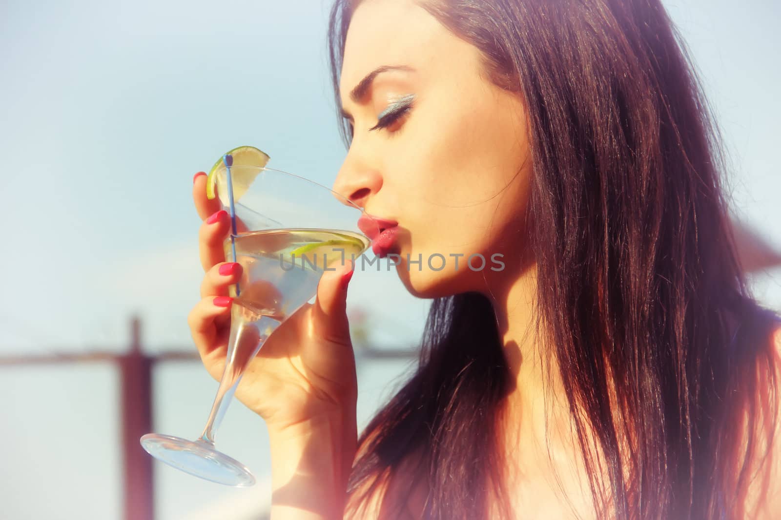 Attractive young girl drinking martini by levonarakelian