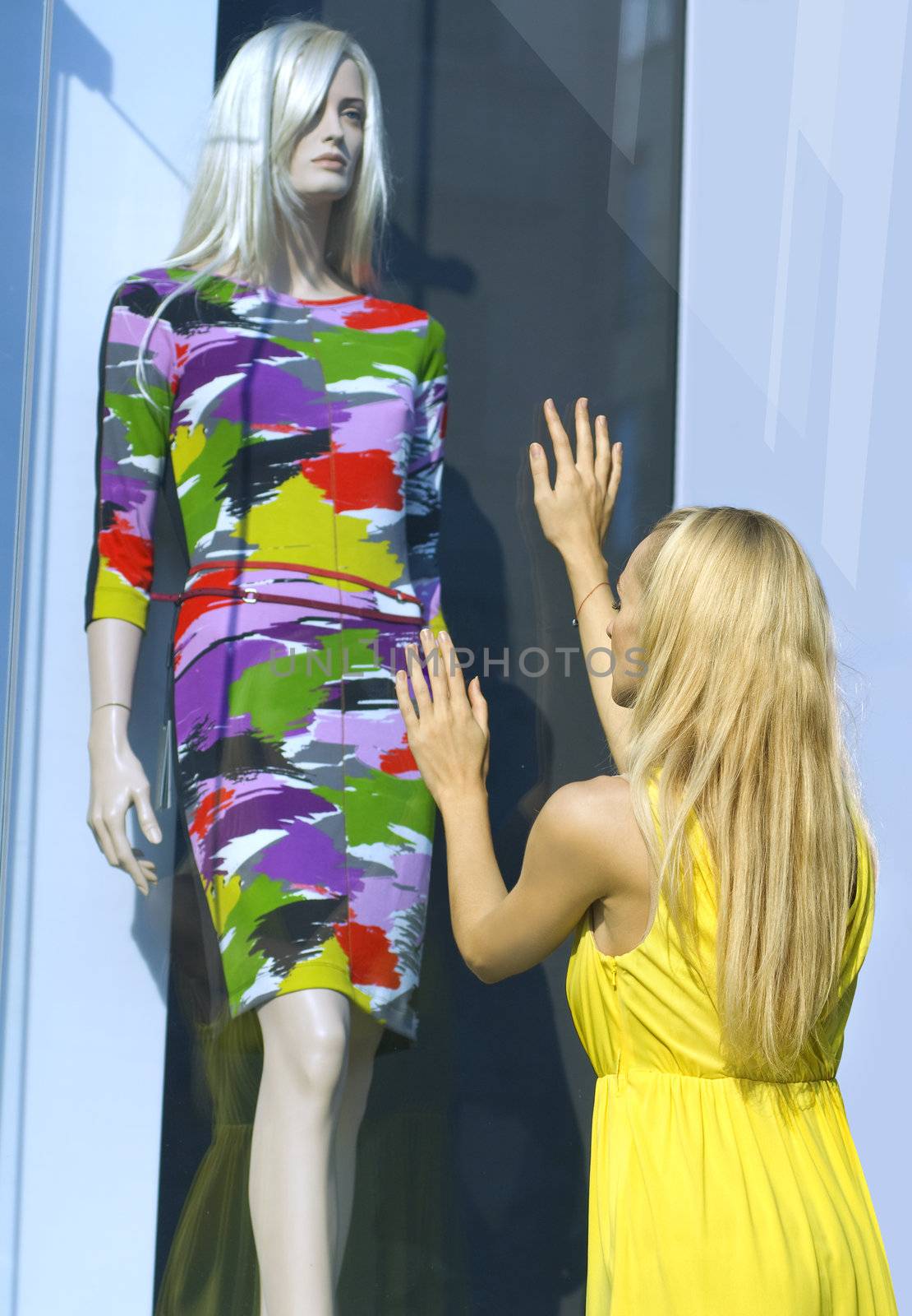 a blonde in yellow dress near the show-window and dummy