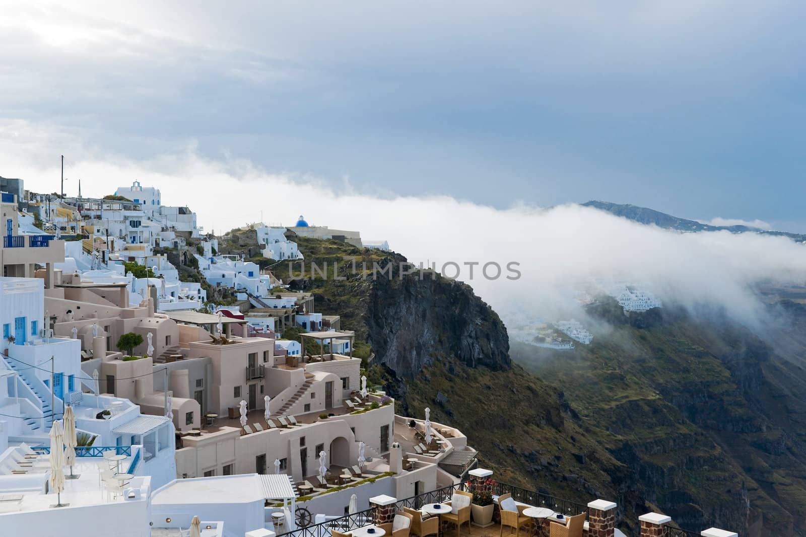 Santorini buildings and cliffs in the morning fog