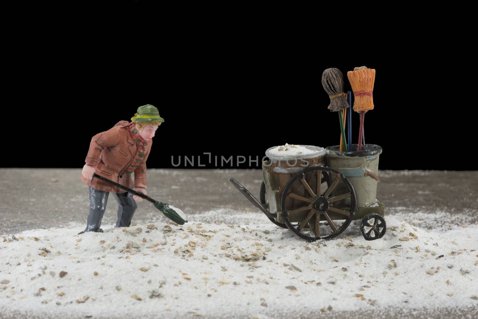 man cleaning the street from sand in the dark