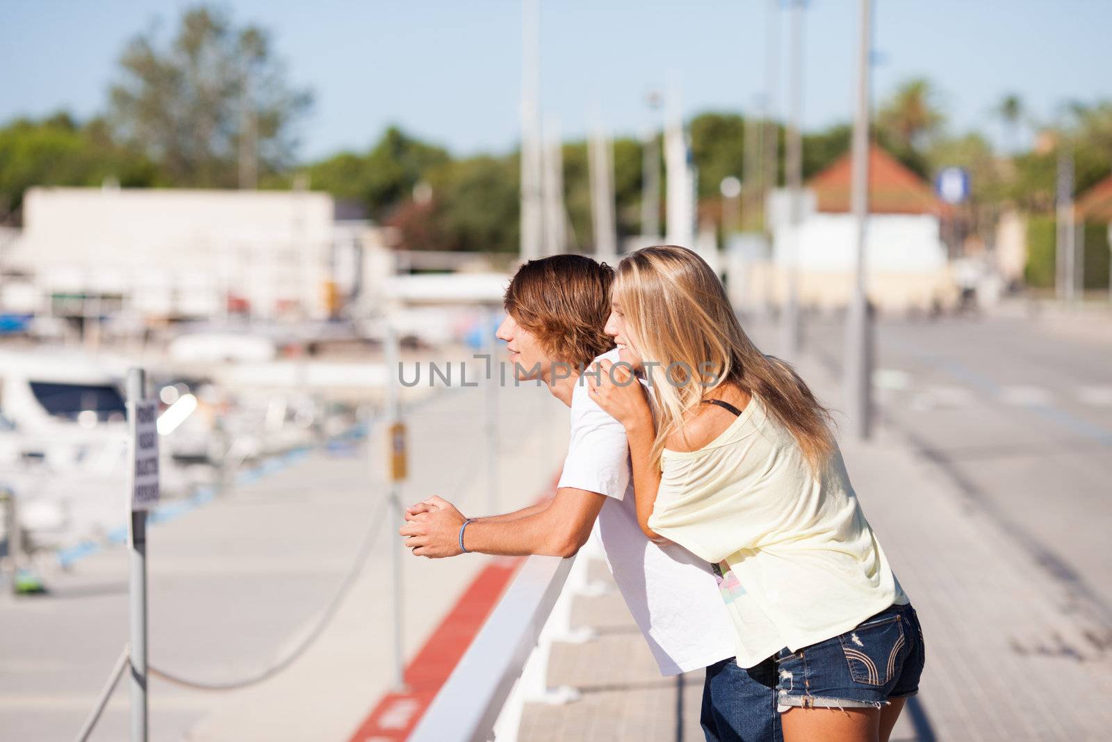 Young beautiful couple enjoying a walk by the harbour