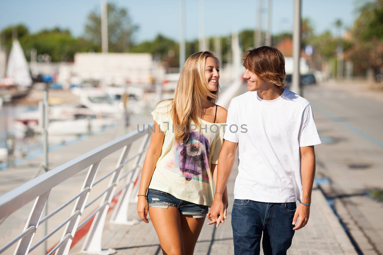 Young beautiful couple enjoying a walk by the harbour