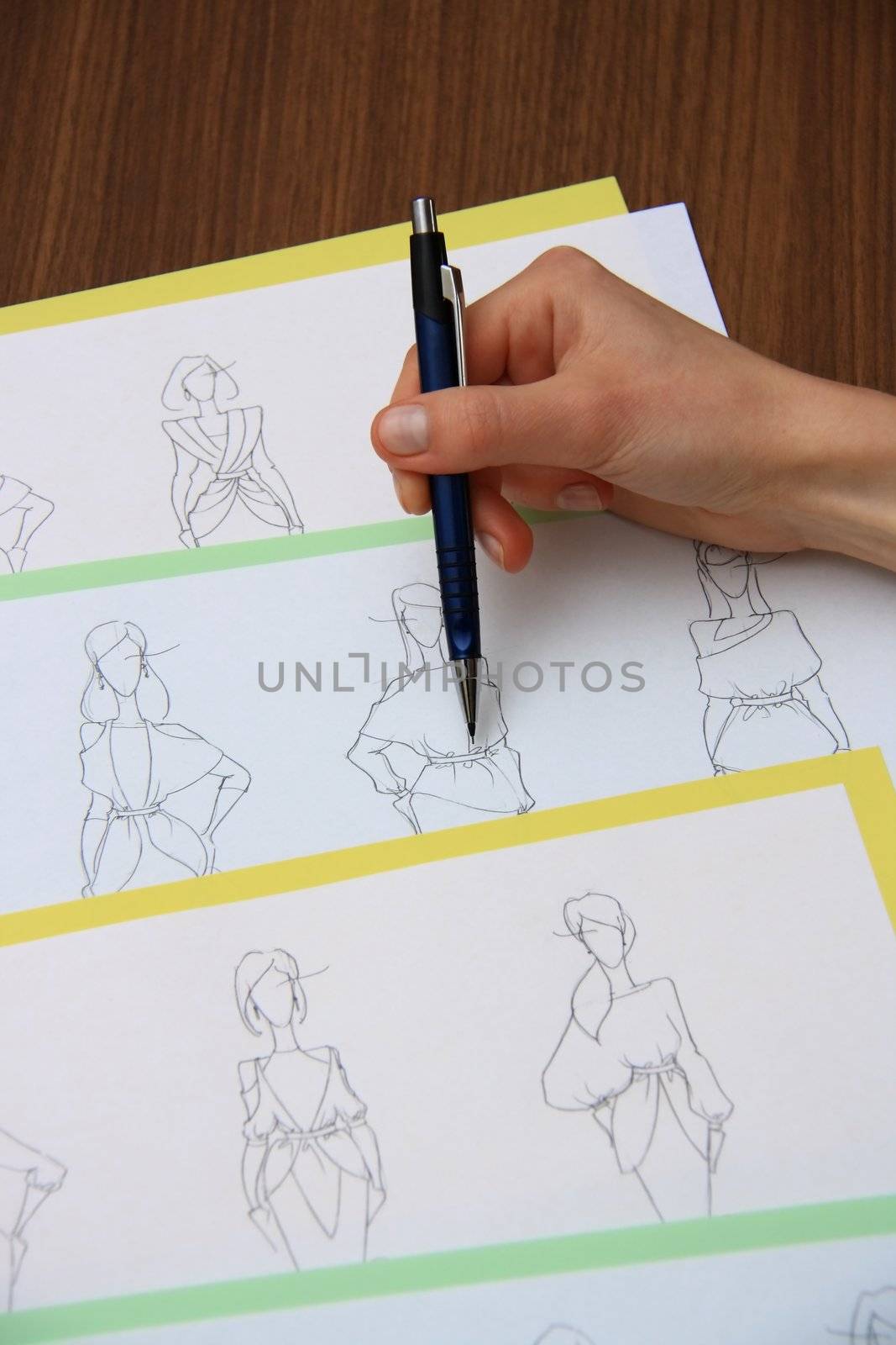 designer assessing fashion drawings on the collection of clothes