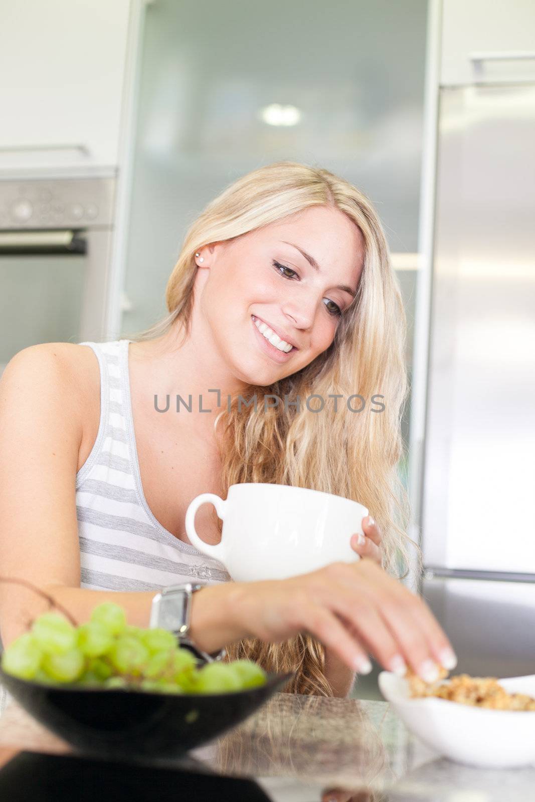 Young beautiful woman enjoying healthy breakfast in the kitchen by Lcrespi