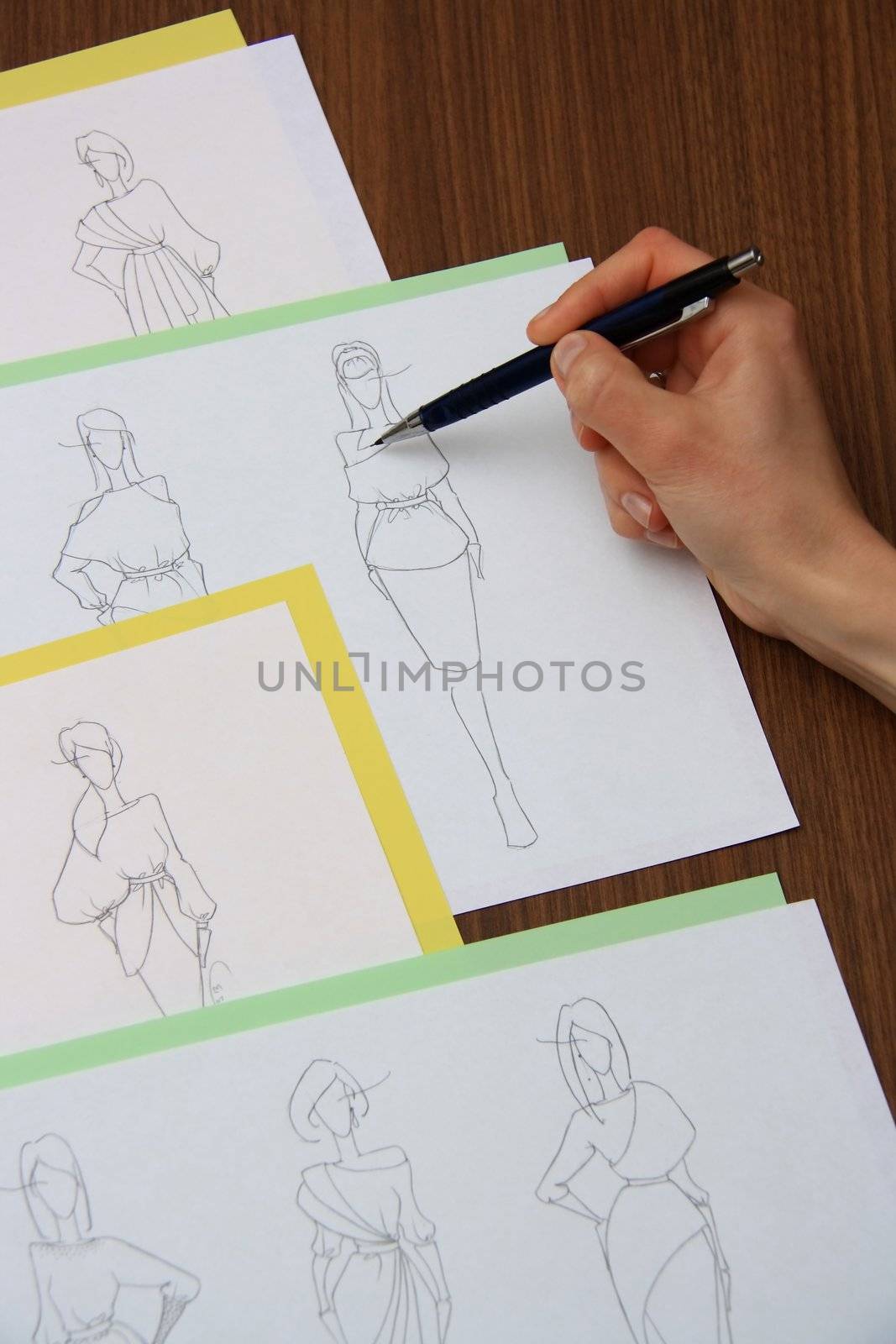 designer assessing fashion drawings on the collection of clothes