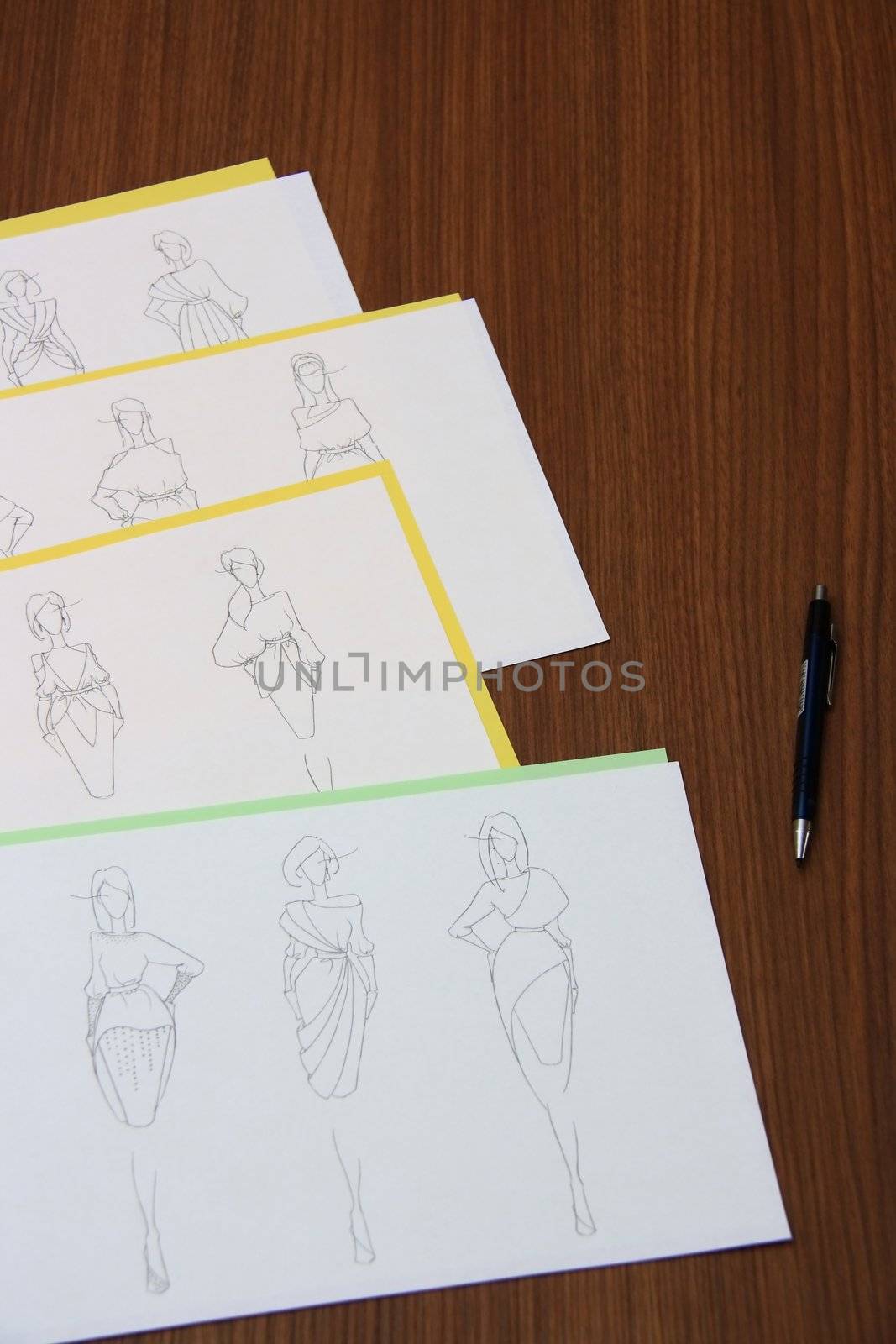 designer assessing fashion drawings on the collection of clothes