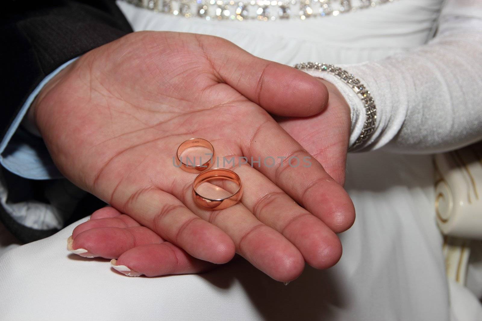 Wedding rings in hands of the newlyweds