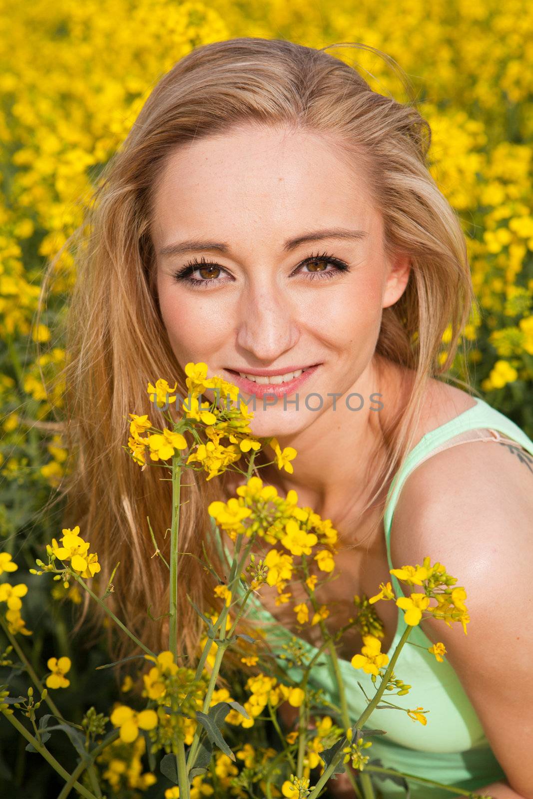 young beautiful blonde girl in a field in summer happy