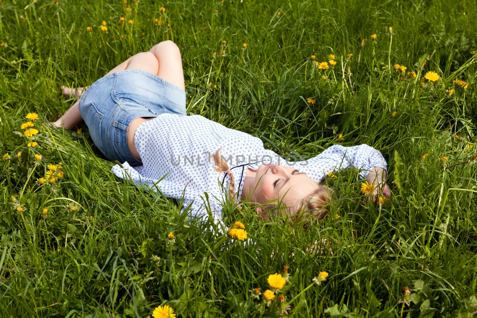 young woman lying in green gras happy by juniart