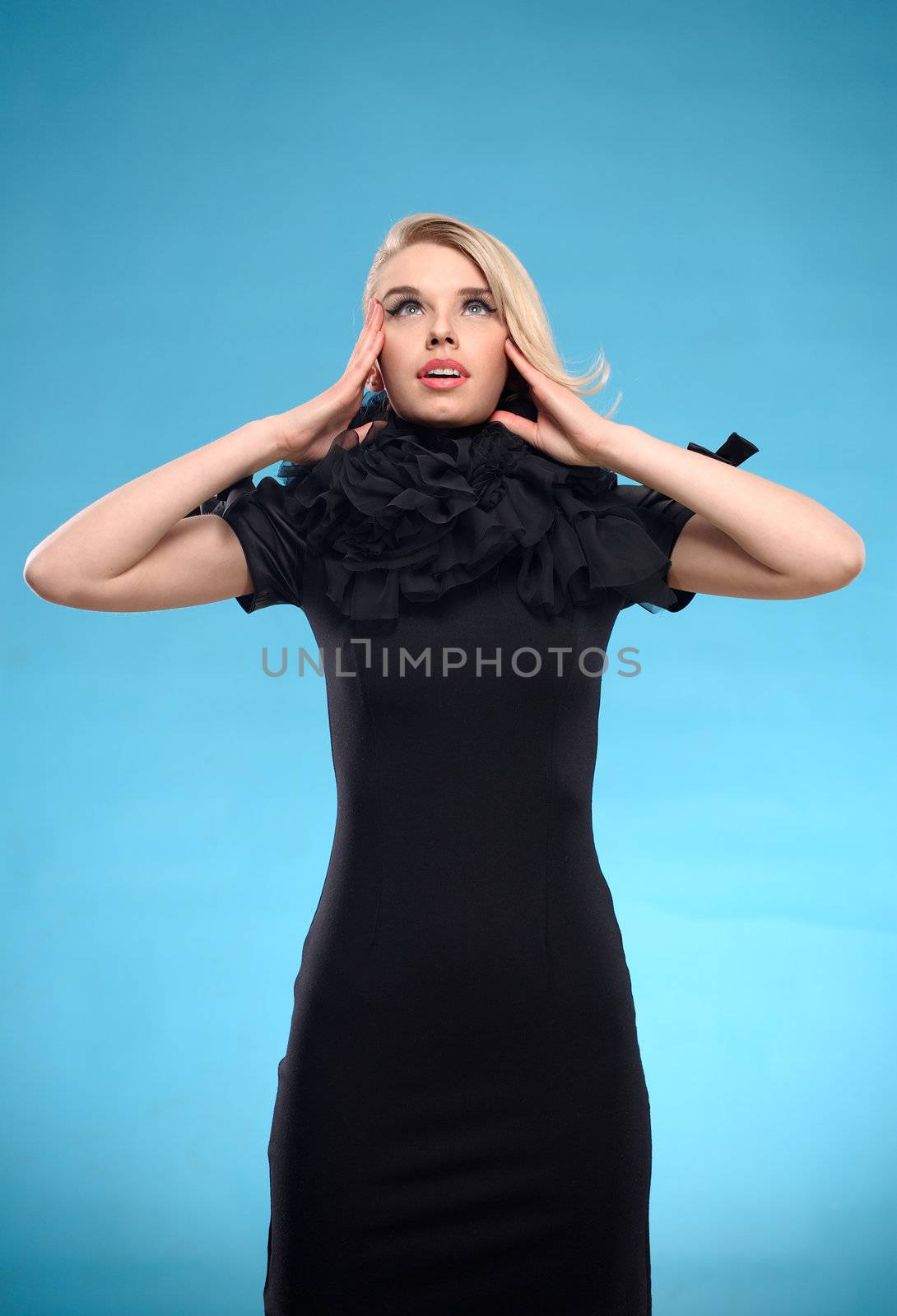 Beautiful blond woman with elegant black formal dress. Over blue background