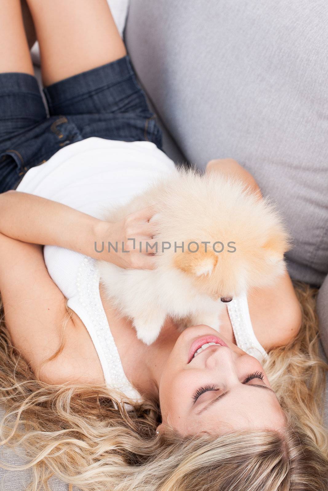 young woman playing with her tinny dog at home