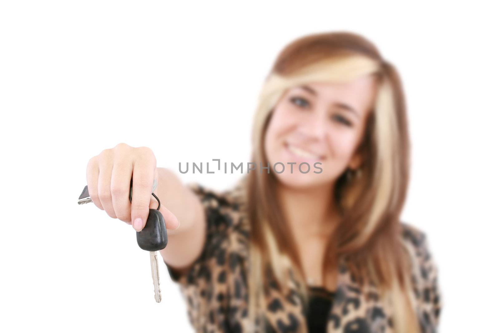 Young caucasian woman holding car key. Image with shallow depth of field. The key is in focus.