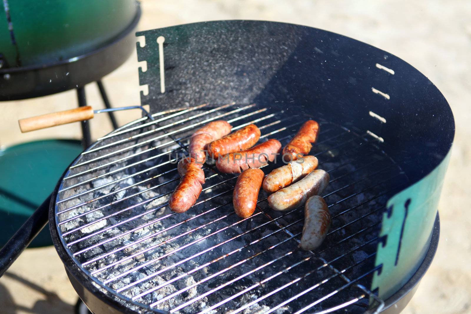 Delicious grilled sausages on gridiron at sunny day