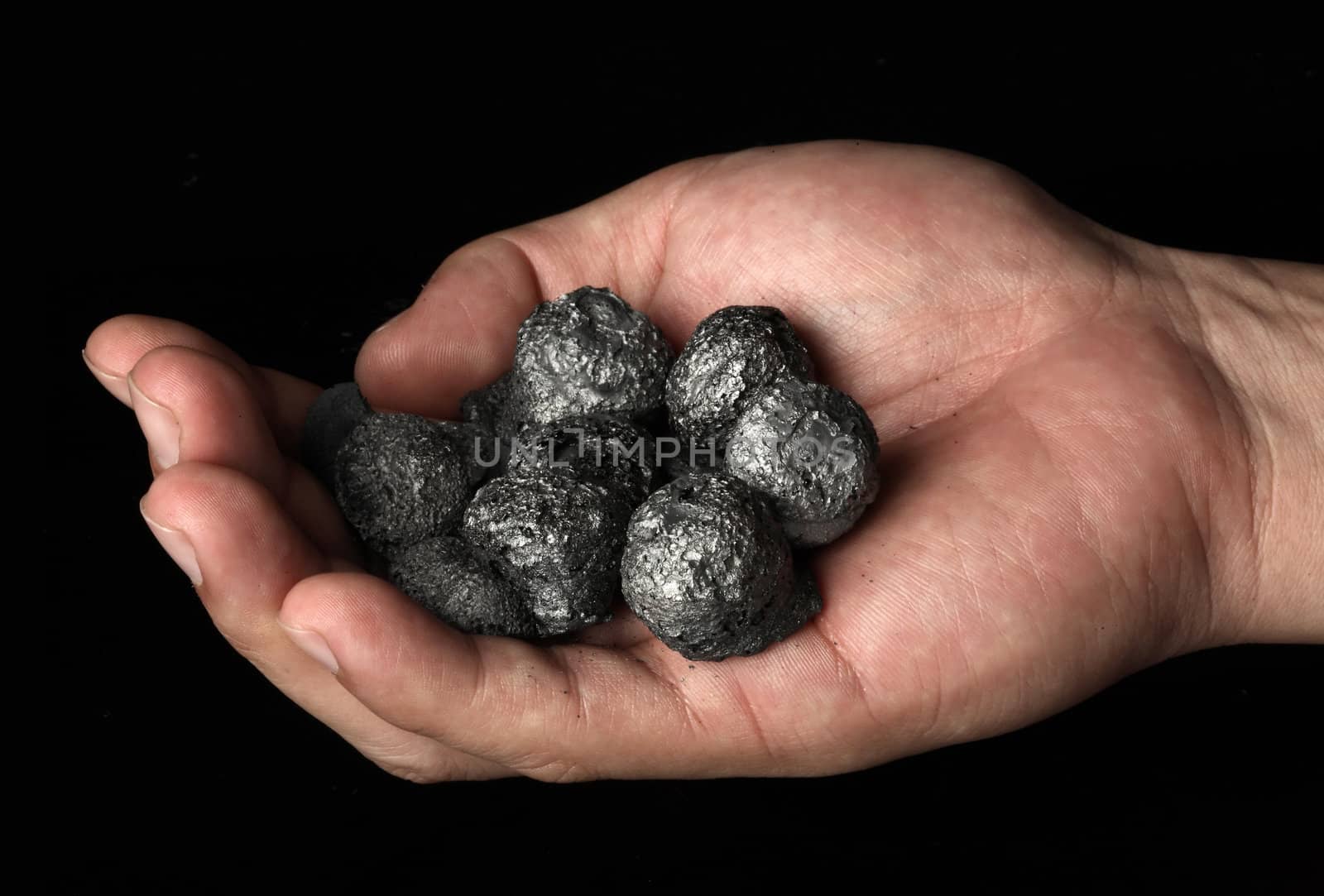 Hand holding a bunch of high quality coke coal. Research and development concept