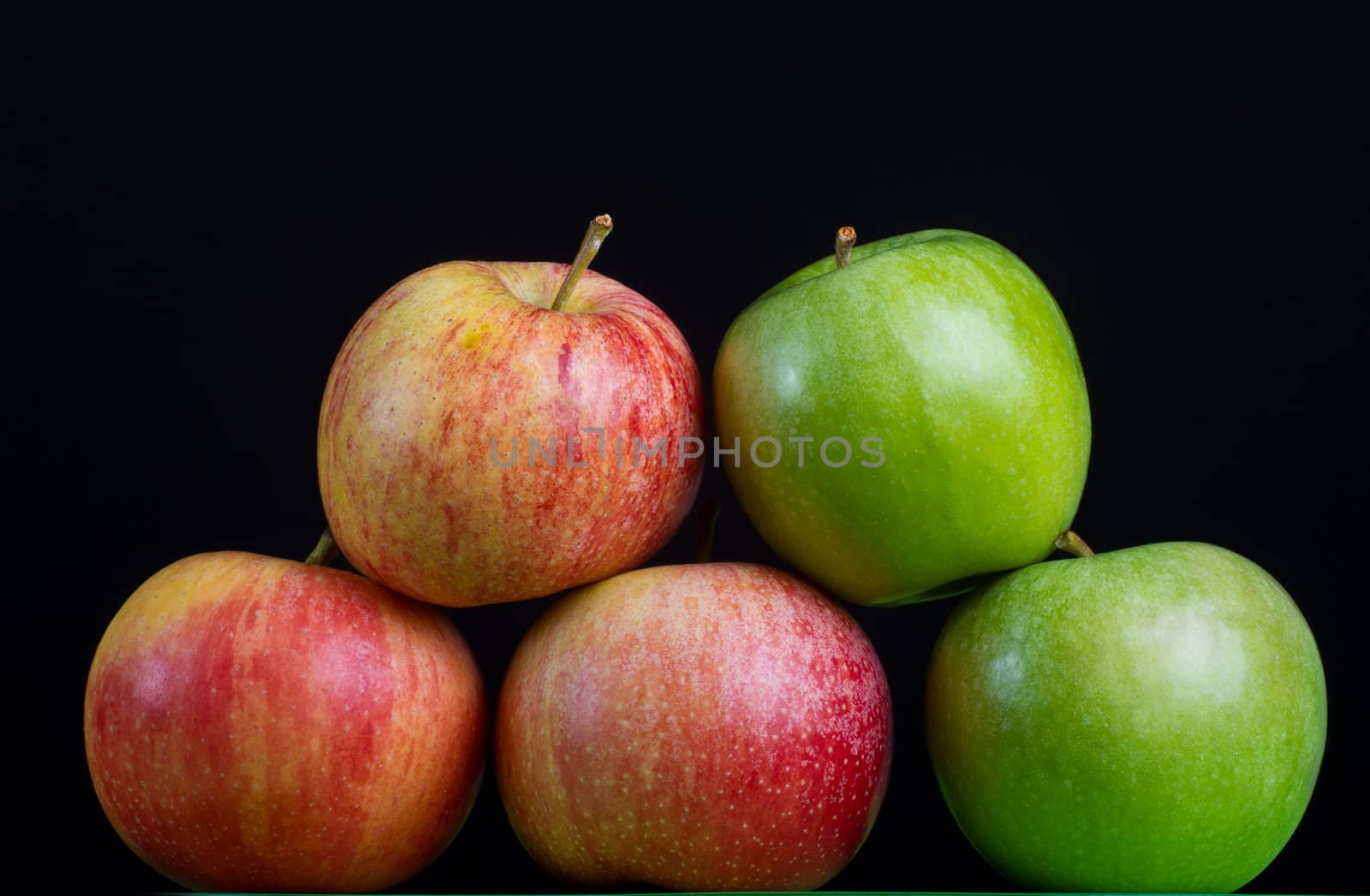 Apples in a row on black backround