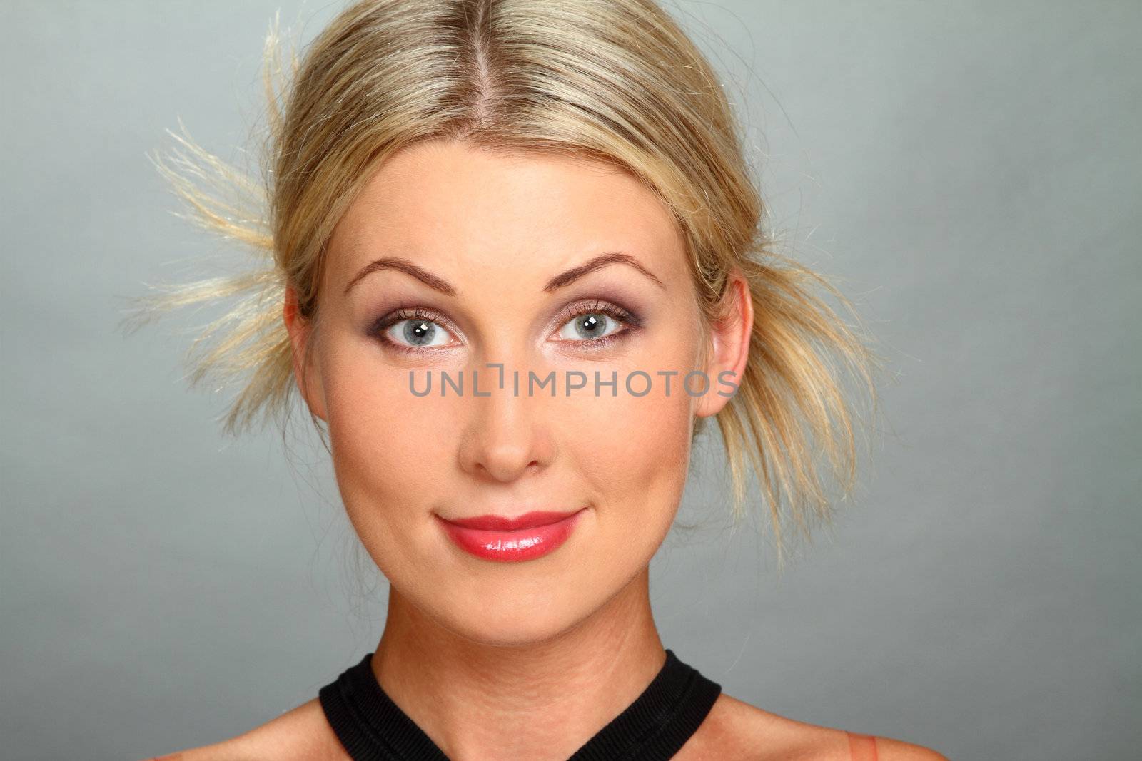 Portrait of the beautiful girl-blonde with gray eyes. Looks in the camera. A close up.