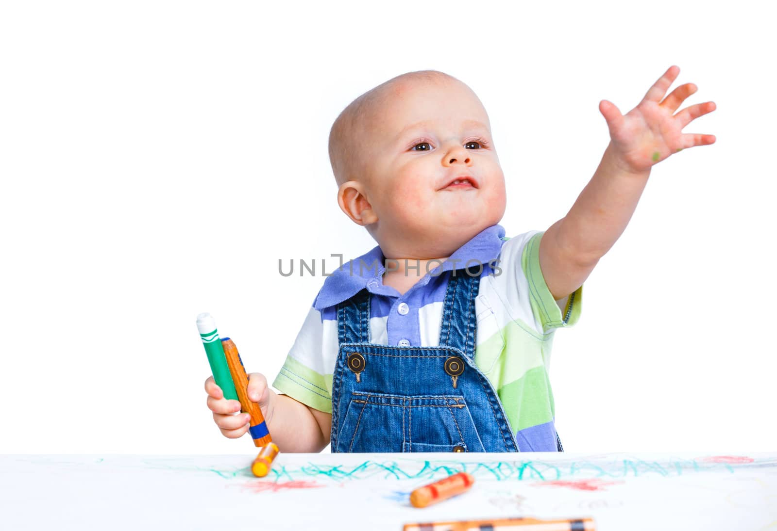 Portrait clouse-up of little sweet boy draws with crayons in red, isolated on white