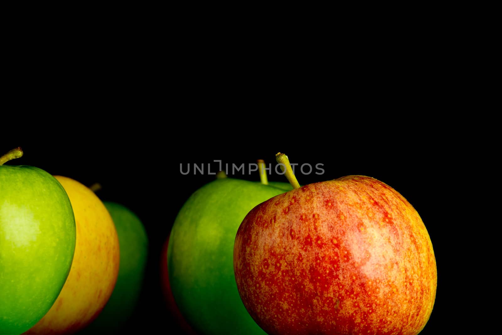 Apples in a row on black backround