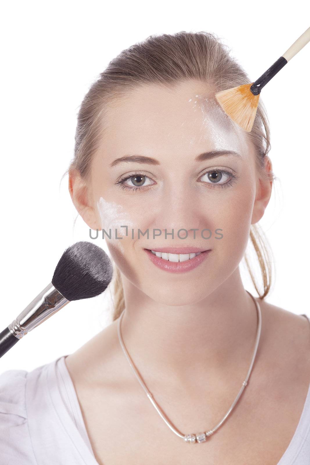 young beautiful woman applying mineral powder on face isolated
