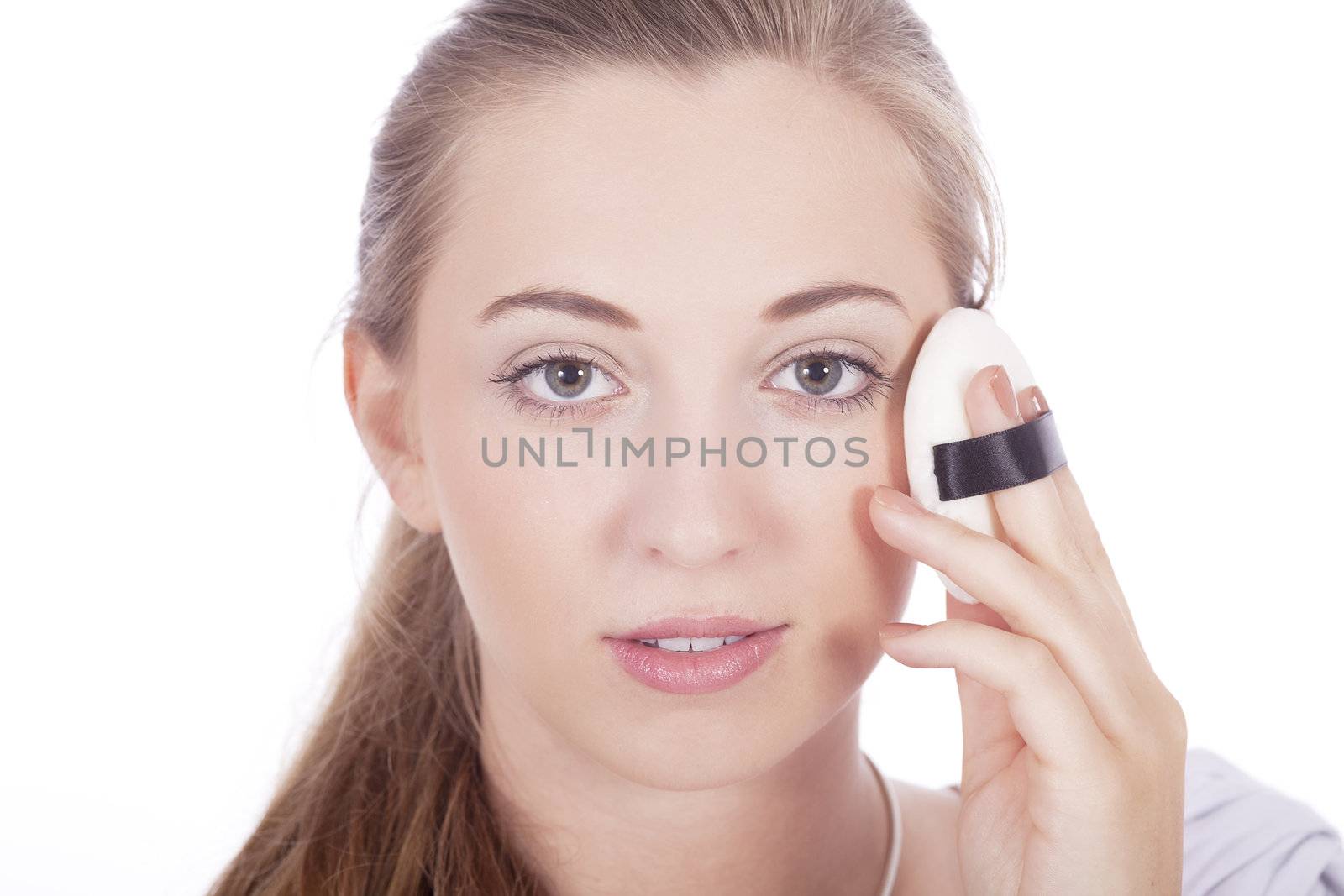 young beautiful woman applying mineral powder on face isolated