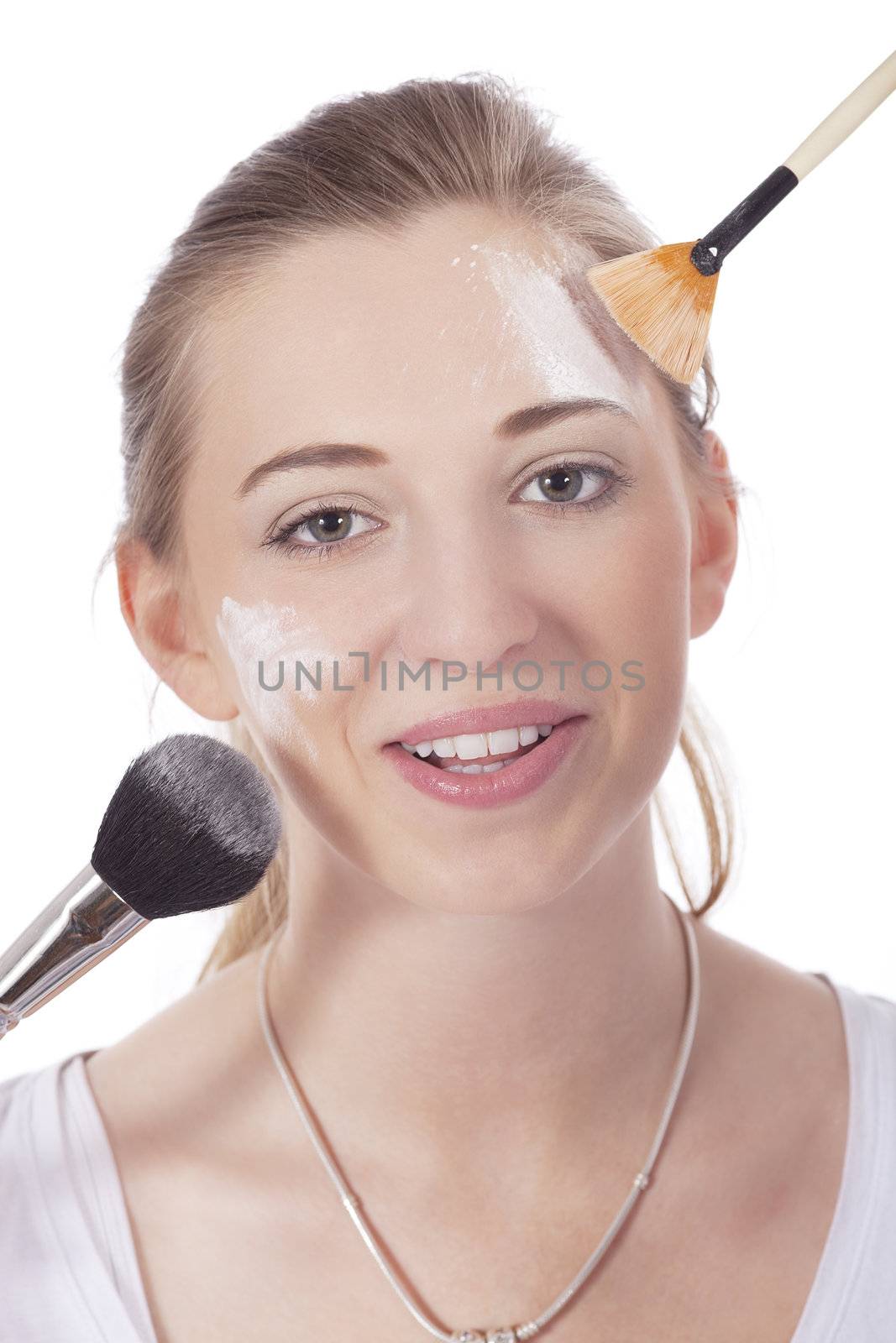 young beautiful woman applying mineral powder on face isolated