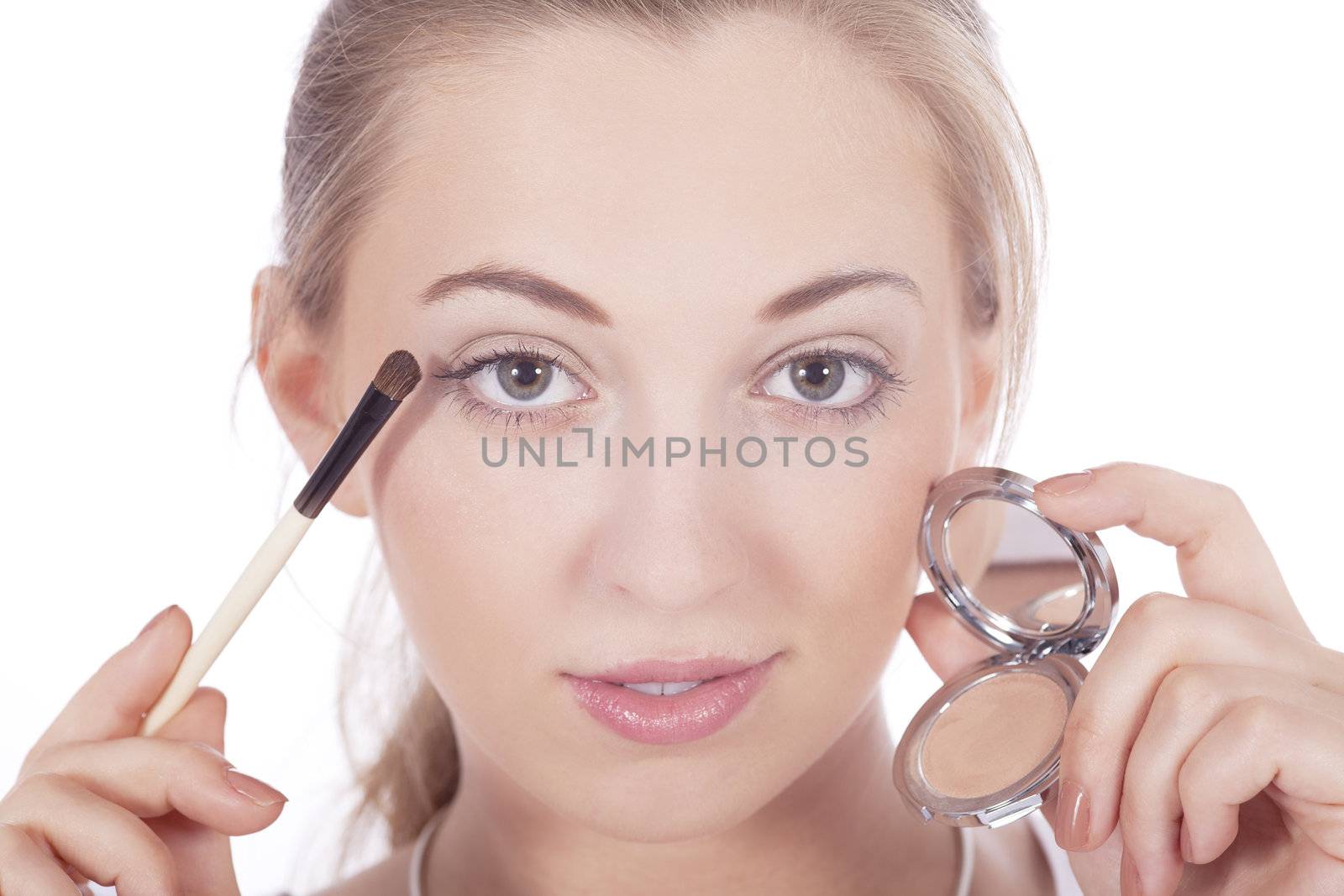 young beautiful woman applying eyeshadow on eyes isolated