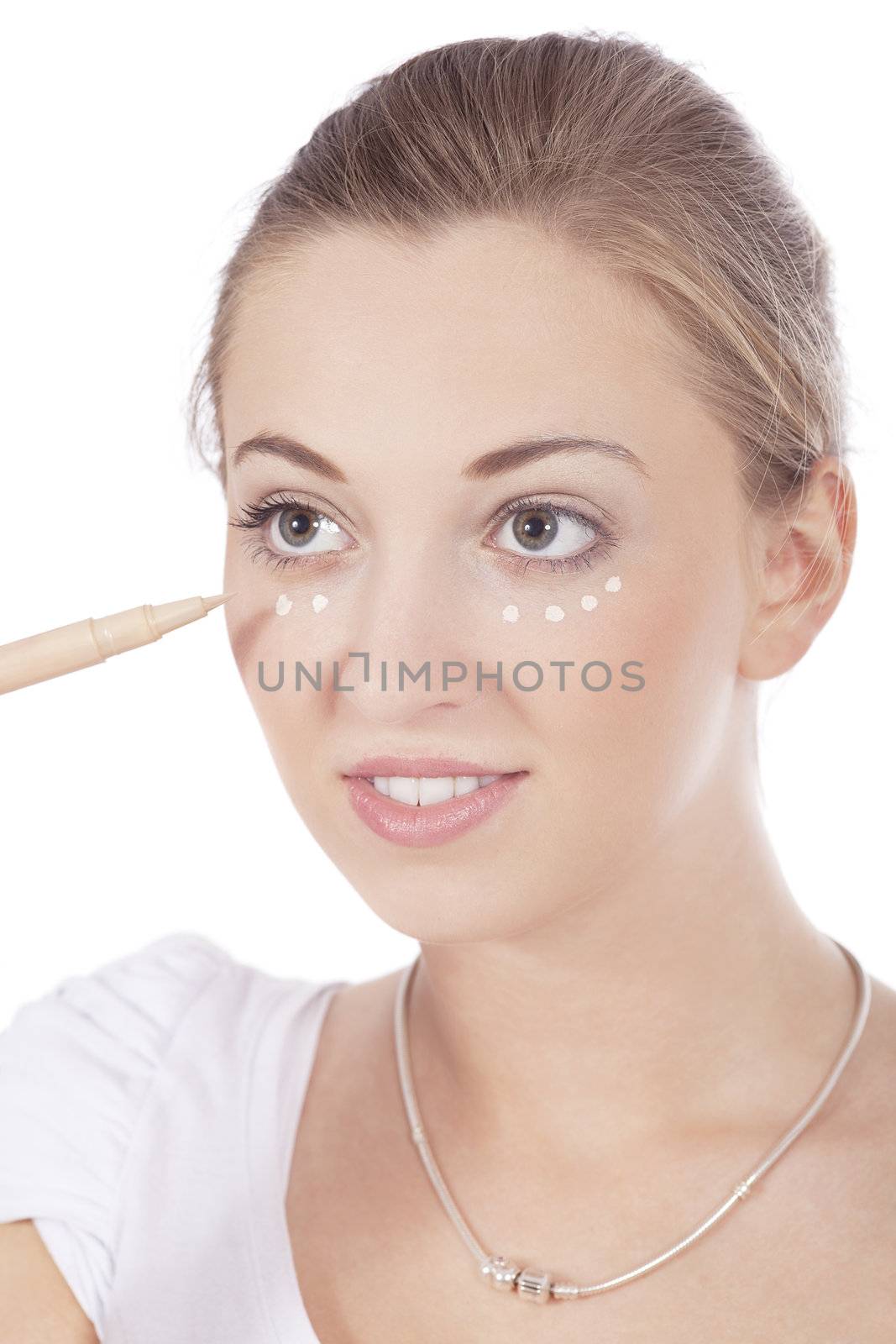 young beautiful woman applying concealer on face isolated