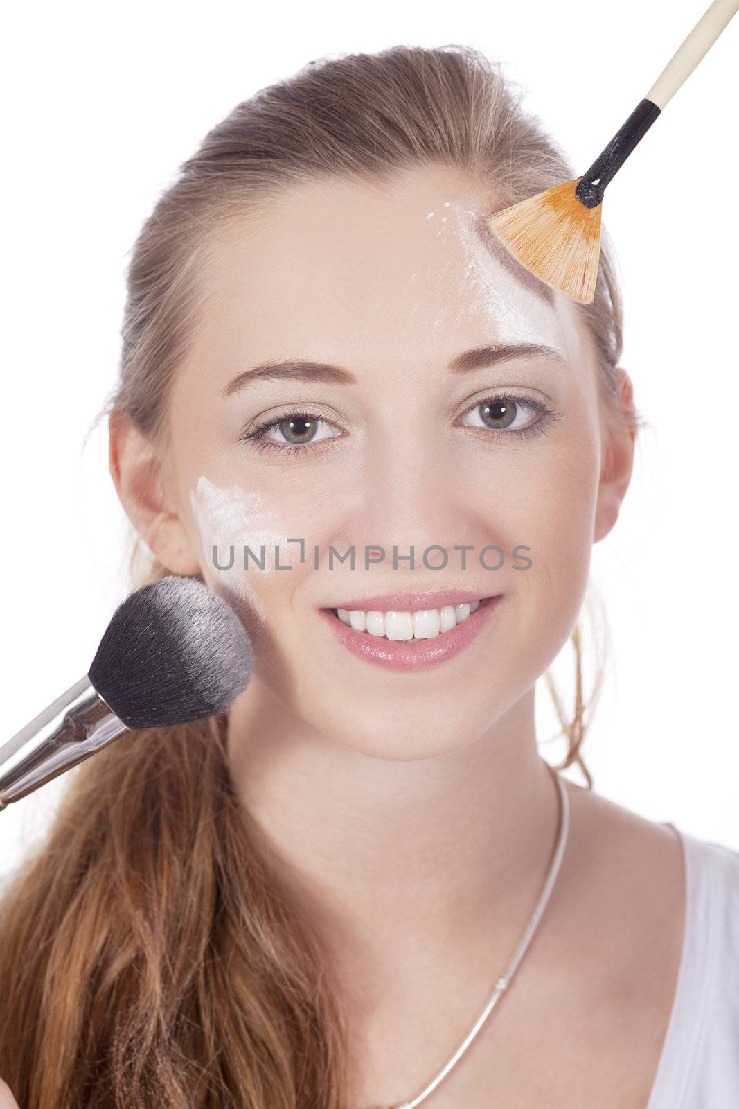 young beautiful woman applying mineral powder on face isolated