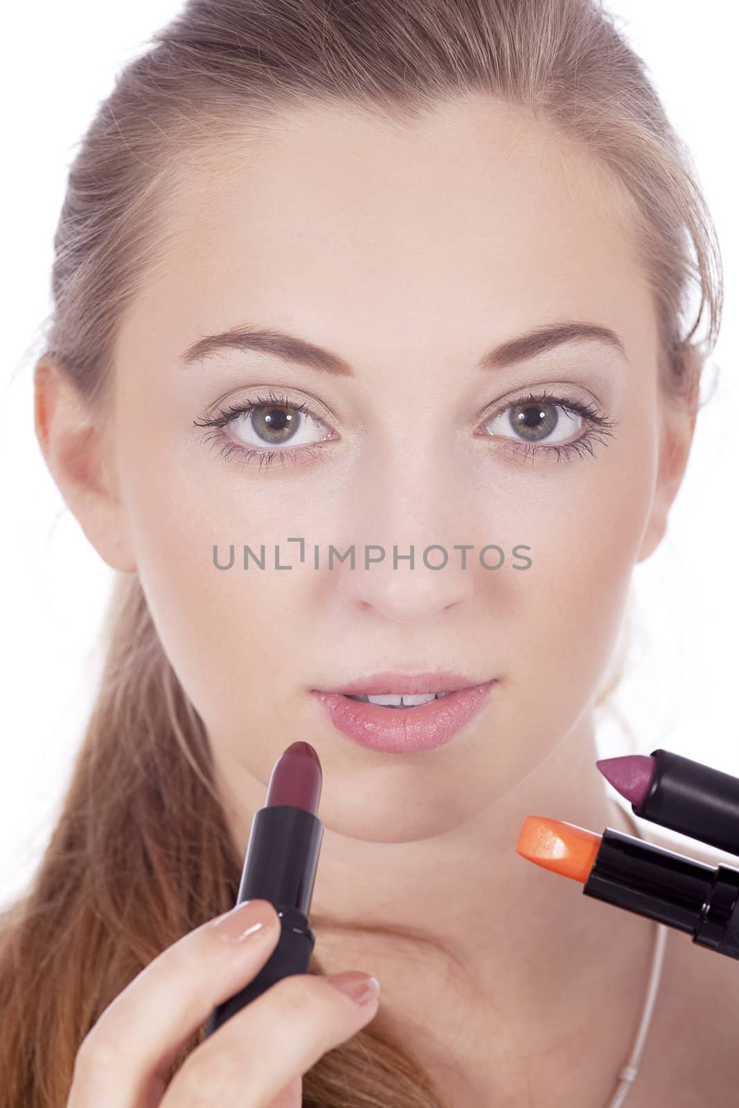 young beautiful woman applying colored lipstick on lips isolated