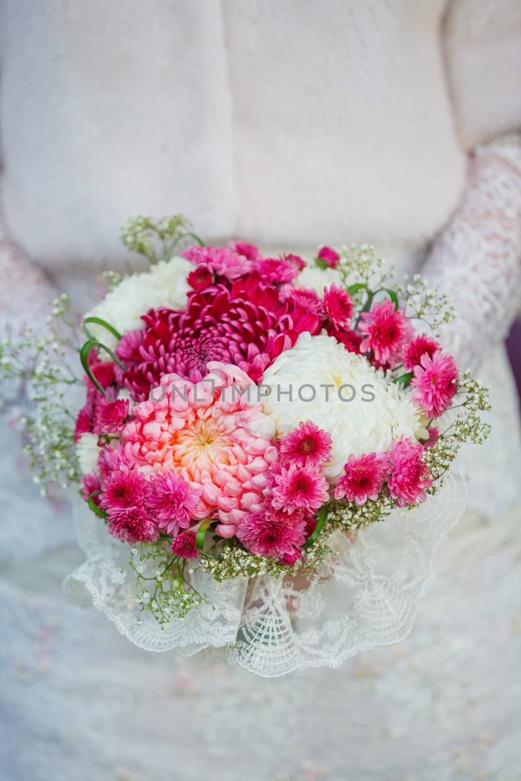 Bride holding purpur wedding bouquet in the yours hand. Vertical view