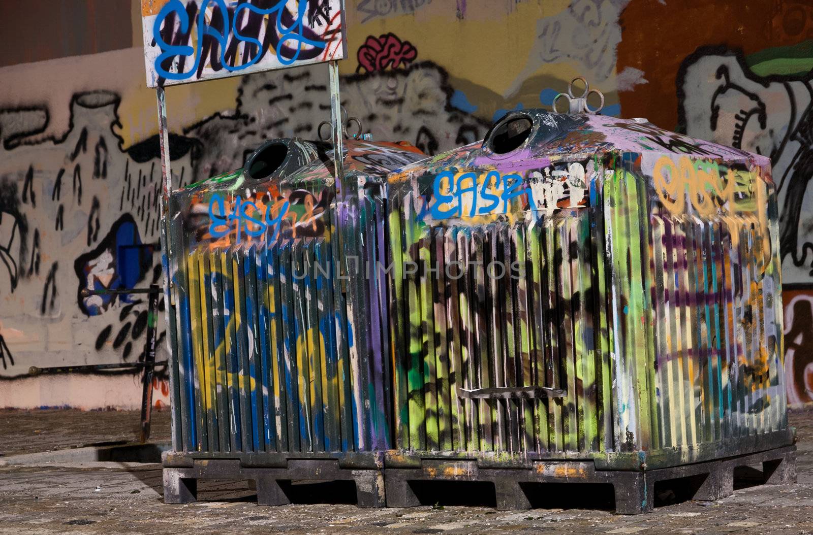 Picture of two tagged trashcans in a city