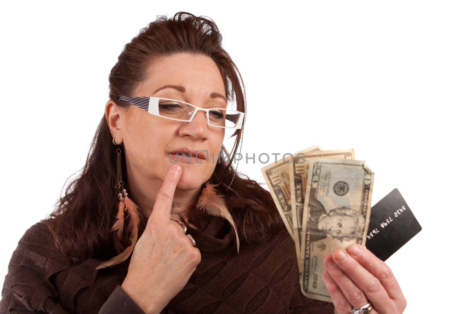 Middle aged woman carefully trying to decide between using old fashioned cash or a plastic credit card.